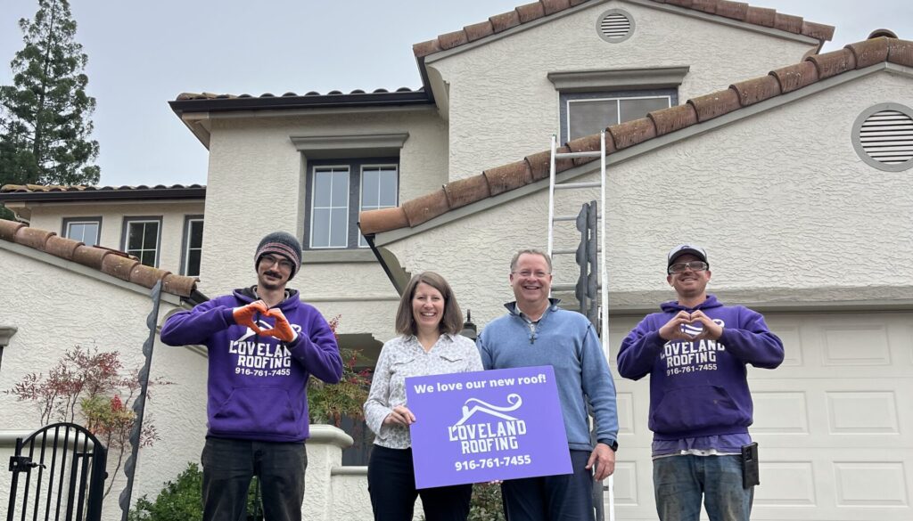Loveland Roofing team and homeowners in front of a completed roofing project