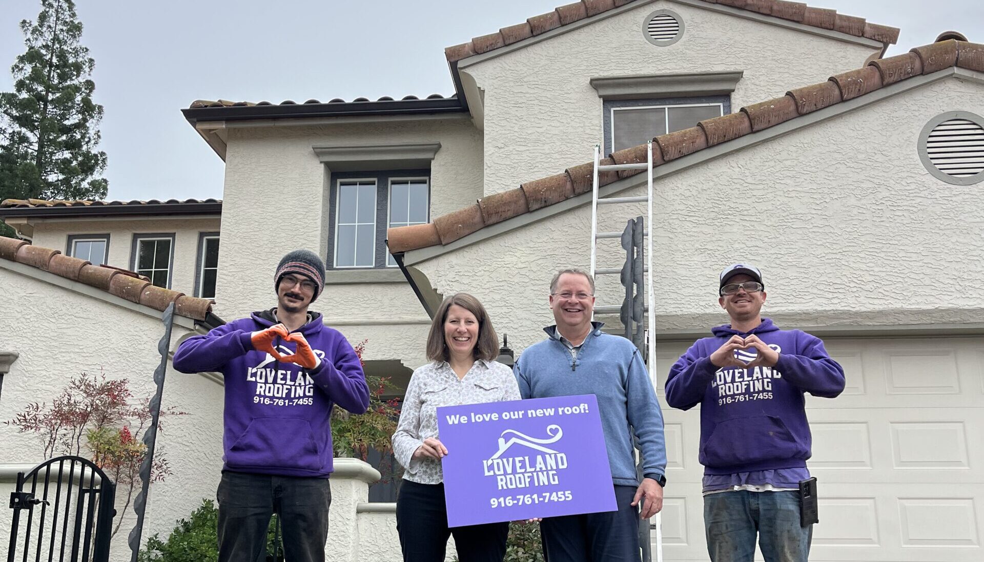 Loveland Roofing team and homeowners in front of a completed roofing project