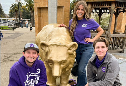 The Loveland Roofing team posing in front of a metallic bear statue