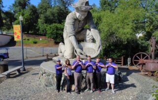 Loveland Roofing team in front of a statue of a prospector.