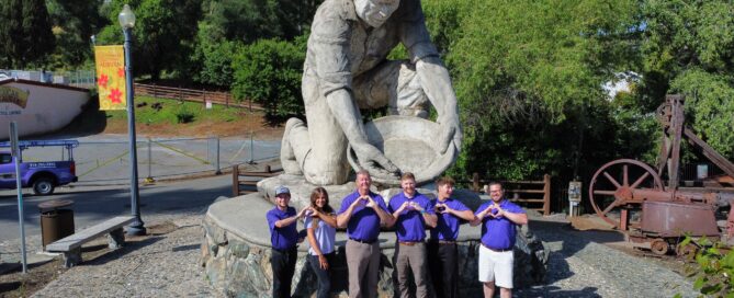 Loveland Roofing team in front of a statue of a prospector.